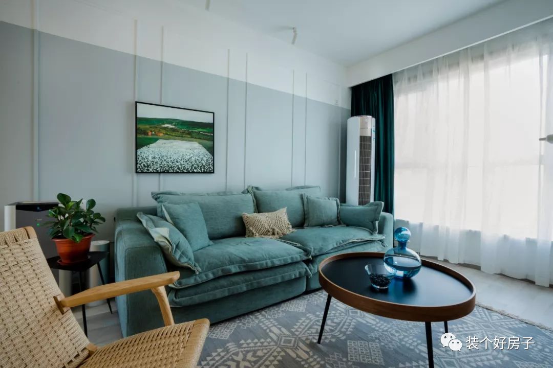 走过玄关向走转,是宽敞的客厅,客厅整体以莫兰迪色系的雾霾蓝搭配木质